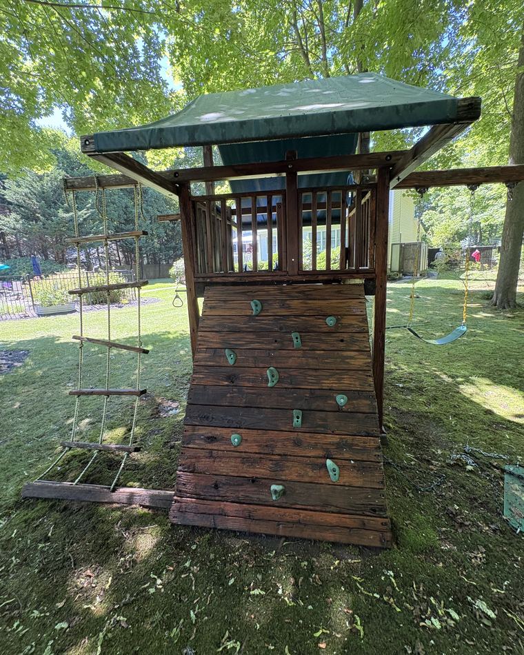 The same playset restored to clean brown timber after cleaning