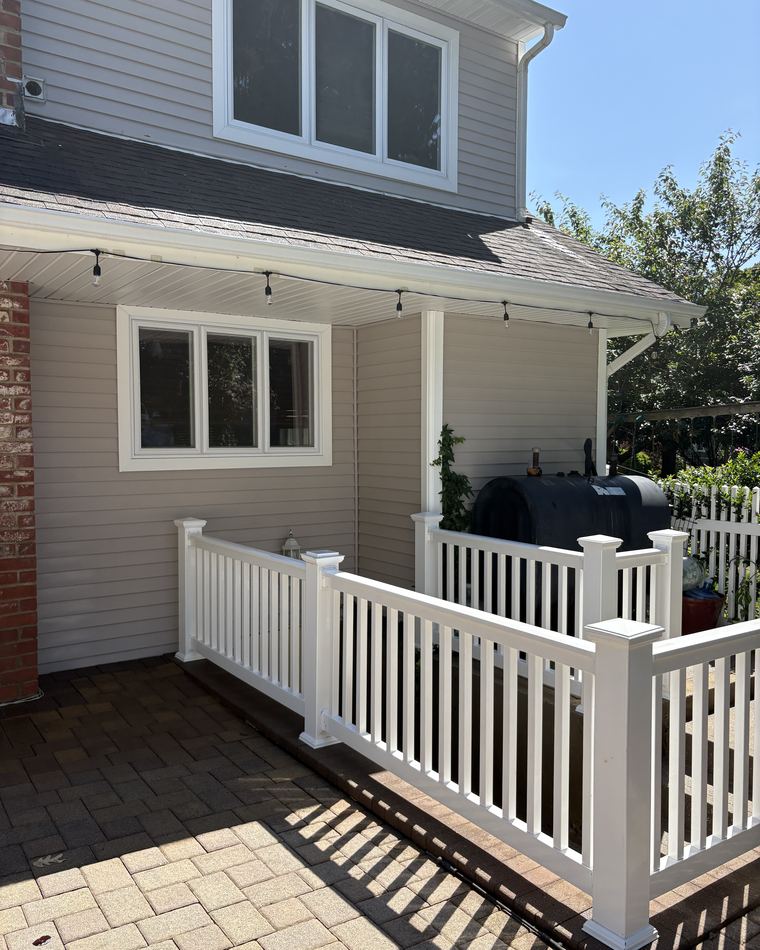 A freshly cleaned deck with white railings and warm-toned boards