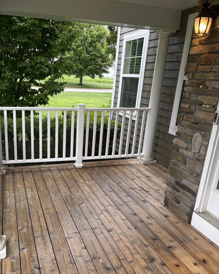 Clean cedar-shake siding, stone facing and a white porch column after soft washing