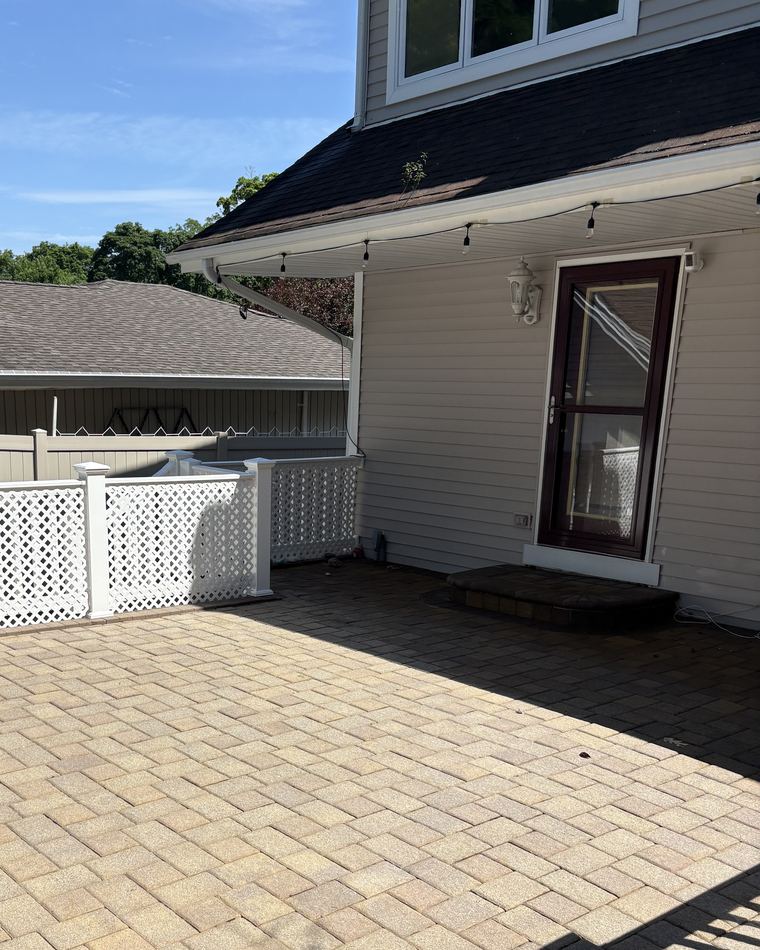 A clean dark shingle roof and white gutter line against a blue sky